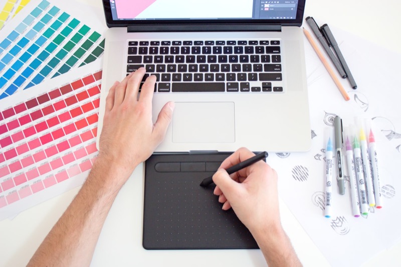 Designer developing brand marks with colour swatches and sketches